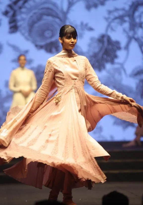 Model twirling in a flowing handloom anarkali on the ramp